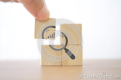 Hand complete magnifying glass with crop and increasing graph inside icon on wood block for business growth, focus on target Stock Photo