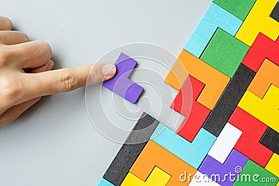 Hand connecting geometric shape block with colorful wood puzzle pieces. logical thinking, business logic, Conundrum, decision, Stock Photo