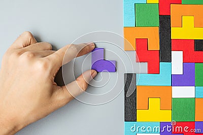 Hand connecting geometric shape block with colorful wood puzzle pieces. logical thinking, business logic, Conundrum, decision, Stock Photo