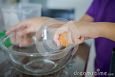 Hand Cracking an Egg into a Bowl. Cooking at home Stock Photo