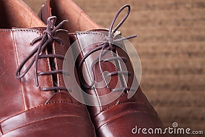 Hand crafted Brown Leather Shoes kept on a Wooden Floor Stock Photo