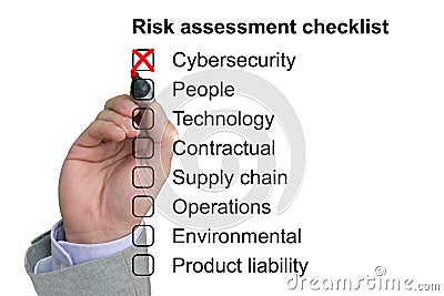 Hand crosses off first item of a risk assessment checklist Stock Photo