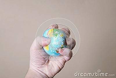 Hand crushing globe of planet earth - ecocide or destruction of environment concept Stock Photo