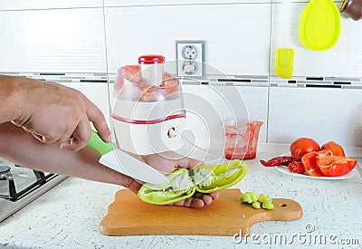 Hand cut with a knife the green pepper on a cutting board. Juicing fresh vegetables. Fresh Juice Stock Photo