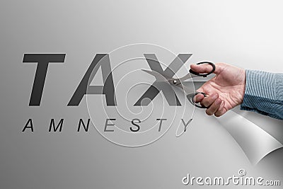 The hand cutting the paper that reads tax amnesty Stock Photo