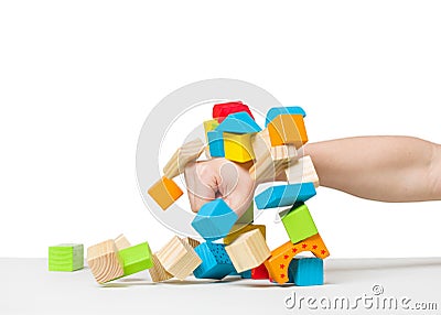 Hand destroying house made of color wooden blocks Stock Photo