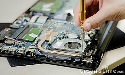 Hand dismantle the laptop. Laptop repair with a screwdriver. Close up Stock Photo