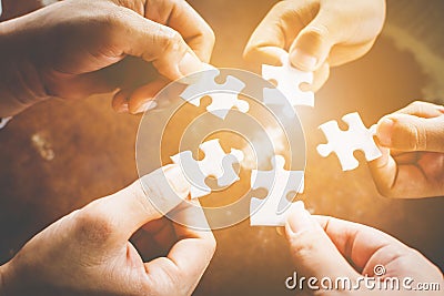 Hand of diverse people connecting jigsaw puzzle. Concept of partnership and teamwork in business Stock Photo