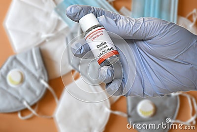 Hand of doctor hold hypothetical vial of Covid-19 vaccine to immunize from the Delta Variant Coronavirus with covid masks on Stock Photo