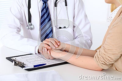 Hand of doctor reassuring her female patient. Medical ethics and trust concept Stock Photo