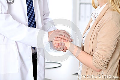 Hand of doctor reassuring her female patient. Medical ethics and trust concept Stock Photo