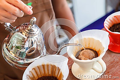 Hand drip coffee, Barista pouring water on coffee ground with filter Stock Photo