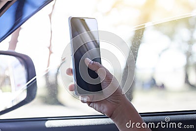 The hand of driver is using a mobile phone to help navigate or GPS. Stock Photo