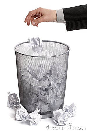 Hand dropping paper into wastepaper bin Stock Photo