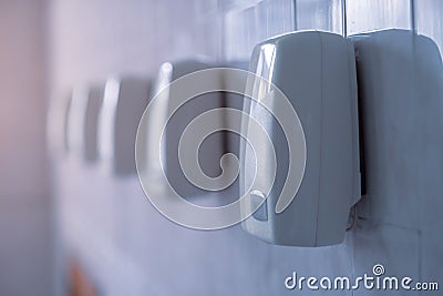 Hand dryer. A row of automatic hand dryers hang on a wall Stock Photo
