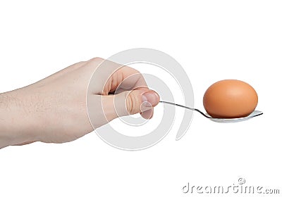 Hand with egg on spoon Stock Photo