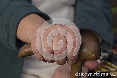 Hand of an elderly woman holding a wooden crutch Stock Photo