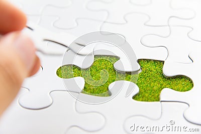 Hand embed missing puzzle piece into place Stock Photo