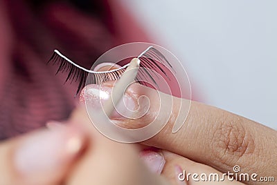 Hand with fake eyelashes Stock Photo