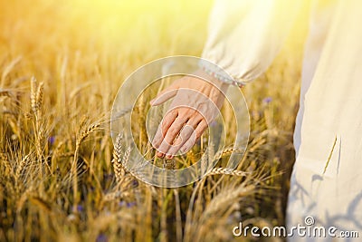Hand of a female in white ethnic shirt touching Stock Photo