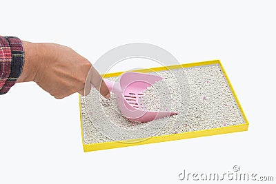 A hand filtering artificial sand with plastic shovel for cat Stock Photo