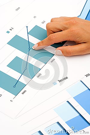 Hand on financial graphics. Stock Photo