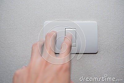 Hand with finger on light switch turn on turn off lights. Stock Photo