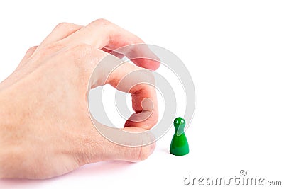 Hand flicking away a small game piece, pawn, finger flick gesture closeup. Layoffs and unemployment abstract business concept Stock Photo