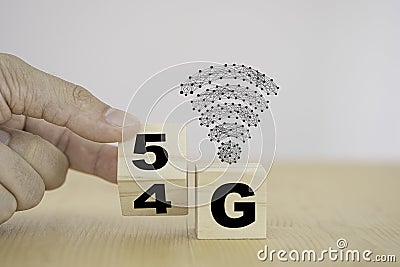 Hand flipping wooden block for change 4G to 5G. 5 Generation wireless technology of mobile signal which big change for internet of Stock Photo