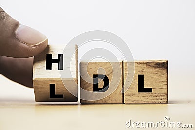 Hand flipping wooden cube block from change LDL to HDL for High is high density lipoprotein and LDL is low density lipoprotein Stock Photo