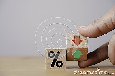 Hand flipping wooden cube block to change between up and down with percentage sign symbol for increase and decrease financial Stock Photo