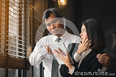 The hand of a flirtatious businessman is embracing his female secretary during counseling Stock Photo