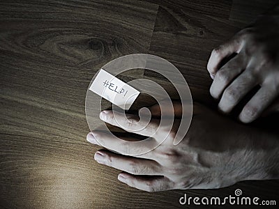 Hand on floor with help note Stock Photo