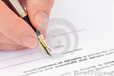 Hand with Fountain Pen Signing a Document Stock Photo