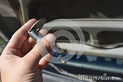Hand Gapping a Spark Plug in Front of Car Stock Photo