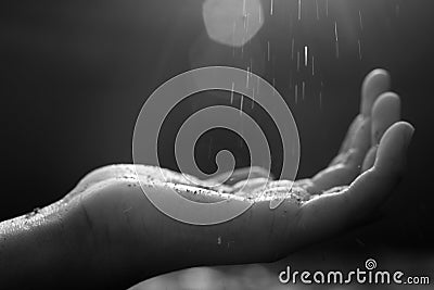 Hand gesture receiving the light of blessings in spiritual concept on black and white abstract art background. New hope concept. Stock Photo