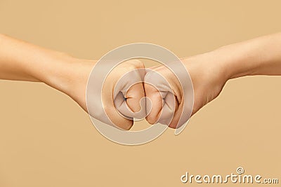 Hand Gestures. Fist Bumping As Popular Greeting Between Best Friends. Handshake Against Beige Background. Stock Photo