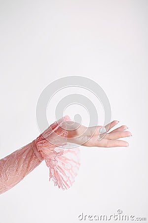 Hand of a girl in a pink lace dress with frills on a white background raised up Stock Photo