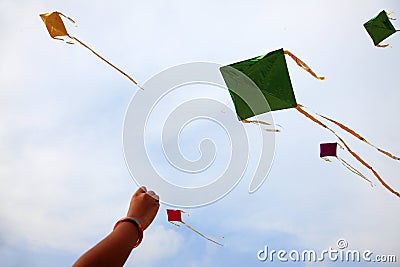 Hand of a girl raises a kite in a sky Stock Photo