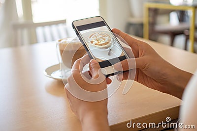 The hand of the girl using the phone to take coffee in the restaurant to post on social media Stock Photo