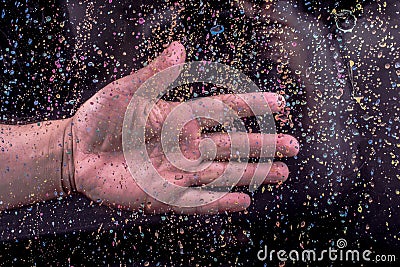 Hand on a glass with a paint splash effect on black background Stock Photo