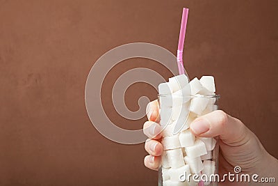 Hand and glass with sugar drink, the concept of excessive consumption of sugar in the diet. Copy space Stock Photo