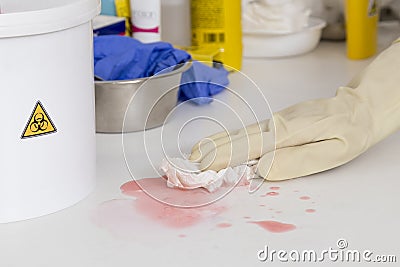 cleaning a spilled liquid next to a container for biological risk Stock Photo