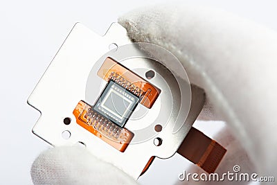 Hand in glove holding camera sensor Stock Photo