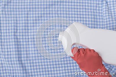 Hand in glove pours liquid for washing on clothes. Close-up Stock Photo