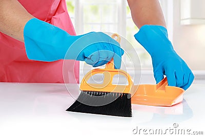 Hand with glove using cleaning broom to clean up Stock Photo