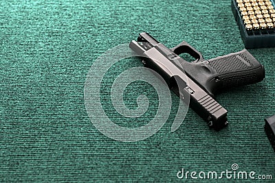 Hand gun with ammunition on military cloth background, 9 mm pistol gun military weapon and pile of bullets at the metal table, Stock Photo