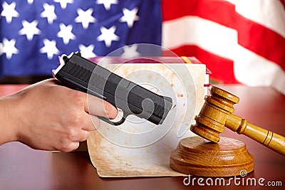 Hand with gun and judges gavel Stock Photo