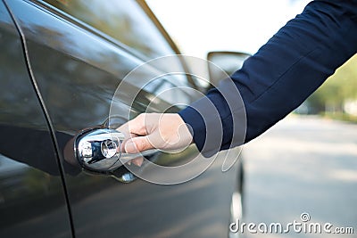 Hand on handle. Close-up of female hand opening a car door Stock Photo
