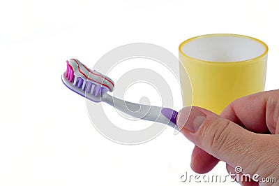 Hand handling toothbrush covered by toothpaste wit Stock Photo